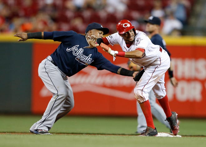 Cincinnati Reds' Billy Hamilton, right, stays balanced on second base after a steal, as Atlanta Braves shortstop Erick Aybar applies the tag during the inning of a baseball game, Monday, July 18, 2016, in Cincinnati. (AP Photo/Gary Landers)