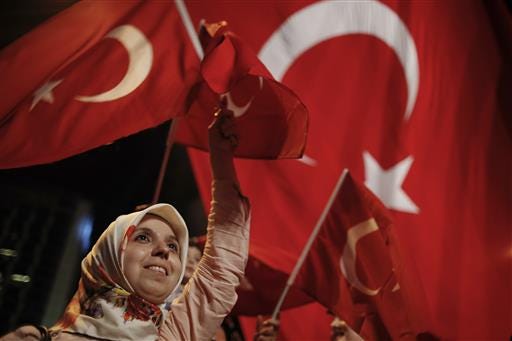 A woman waves Turkish flags during a rally against the attempted coup in Taksim Square in Istanbul, protesting against the attempted coup, Monday, July 18, 2016. The Turkish government accelerated its crackdown on alleged plotters of the failed coup against President Recep Tayyip Erdogan. The rebellion, which saw warplanes firing on key government installations and tanks rolling into major cities, was quashed by loyal government forces and masses of civilians who took to the streets. (AP Photo/Emrah Gurel)