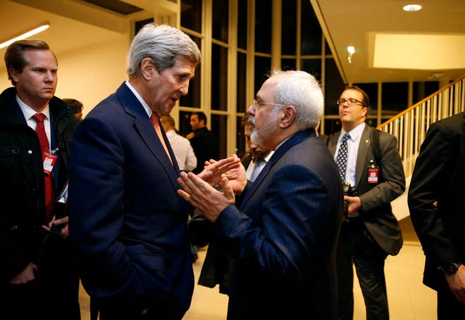 FILE - In this Jan. 16, 2016 file-pool photo, Secretary of State John Kerry talks with Iranian Foreign Minister Mohammad Javad Zarif in Vienna, after the International Atomic Energy Agency (IAEA) verified that Iran has met all conditions under the nuclear deal. A document obtained by The Associated Press Monday, July 18, 2016, says key nuclear restrictions on Iran will ease in a little more than a decade, halving the time Tehran would need to build a bomb if it chose to do so. The document says that 11 to 13 years into the 15-year agreement, Iran can replace the 5,060 inefficient centrifuges it now uses to enrich uranium with up to 3,500 advanced machines. (Kevin Lamarque/Pool via AP, File)