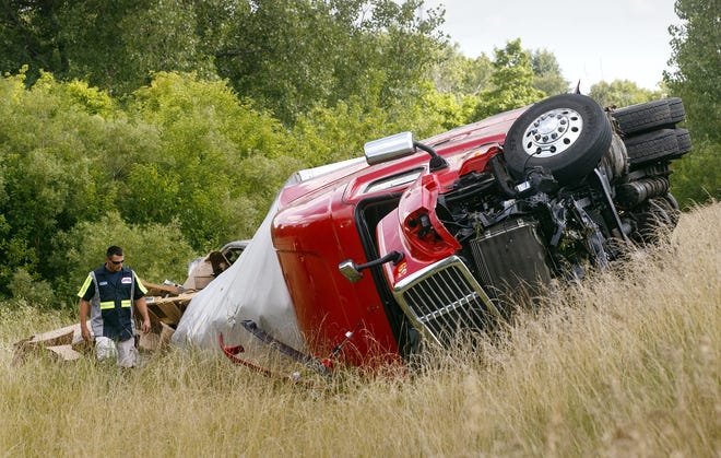 A Shaner´s Towing employee inspects the scene where a tractor trailer rolled down an embankment off Interstate 55 near Glenarm Monday, July 18, 2016. Ted Schurter/The State Journal-Register