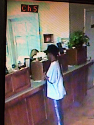 A surveillance photo showing a woman robbing First Madison Bank in Colbert.