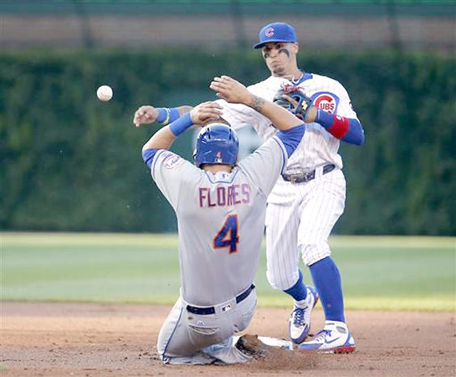 Chicago Cub Javier Baez (right) turns a double play, forcing New York Met Wilmer Flores out at second Monday and getting Asdrubal Cabrera at first, during the second inning in Chicago.  zzz AP Photo/Charles Rex Arbogast