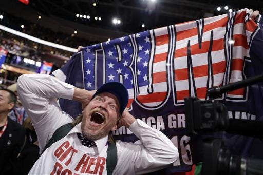 California delegate Jake Byrd reacts as New York delegate Bob Hayssen holds up a Trump flag during the second day session of the Republican National Convention in Cleveland, Tuesday, July 19, 2016.