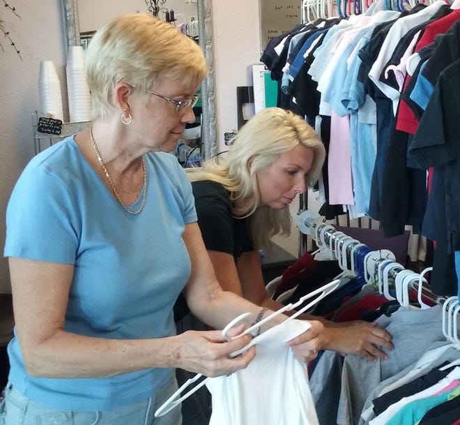 Volunteers Cheryl Kazmier, left, and Brandi Fowler put polo shirts on a rack in preparation for "Project Polo," to be held Saturday. The initiative of Emmanuel's Closet will help struggling families get the shirts required by the Flagler County School District dress code for students in the lower grades. NEWS-JOURNAL/SHAUN RYAN