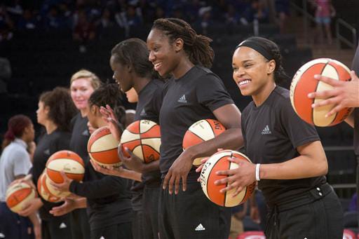 In this Wednesday, July 13, 2016 file photo, members of the New York Liberty basketball team await the start of a game against the Atlanta Dream, in New York. The WNBA has fined the New York Liberty, Phoenix Mercury and Indiana Fever and their players for wearing plain black warm-up shirts in the wake of recent shootings by and against police officers. All three teams were fined $5,000 and each player was fined $500. While the shirts were the Adidas brand - the official outfitter of the league - WNBA rules state that uniforms may not be altered in any way.