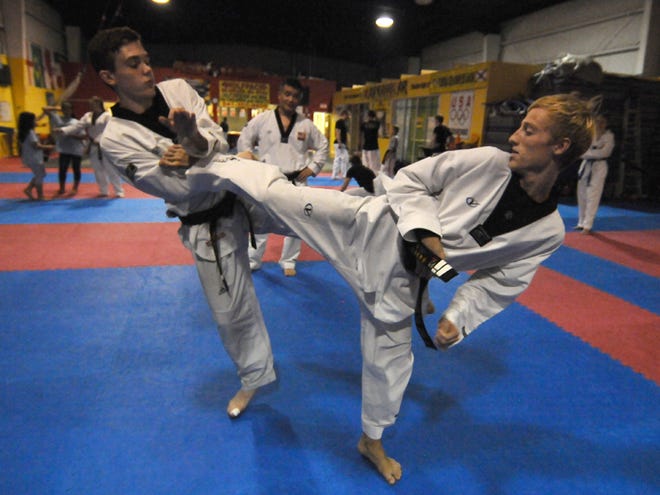 Isaac Weintraub (right) spars with Deven Rutland while master Jin Hwang watches at Red Tiger Martial Arts, July 20, 2016.