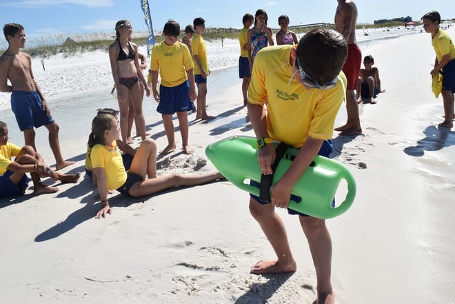 Justin Kazek “wraps the can,” a rescue tech-nique involving a floatation device, as part of a mock rescue exercise.
