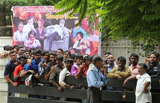 Fans of Indian actor Rajinikanth wait outside a theatre to buy tickets on the eve of release of his new movie Kabali, in Bangalore, India, Thursday, July 21, 2016. Businesses in southern India have given their employees the day off on Friday so they can attend screenings of a new film starring Tamil cinema's superstar Rajinikanth. One of Asia's highest paid actors, Rajinikanth is considered one of the most bankable stars in India. (AP Photo/Aijaz Rahi)