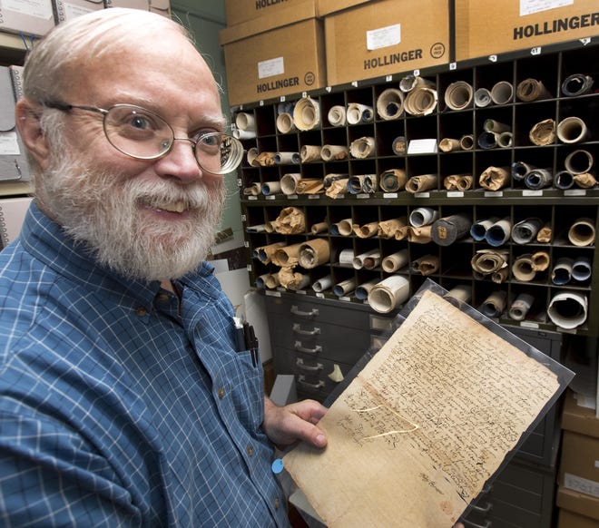 New Hampshire State Archivist Brian Burford poses with a 1726 deed from Widow Brustor at the state's archive vault Friday, in Concord. Bruford used the document at a workshop to help to teach volunteers how to transcribe Civil War-era letters and other documents in hopes that they will offer their services to local historical societies and other groups trying to preserve the state's history. AP Photo/Jim Cole