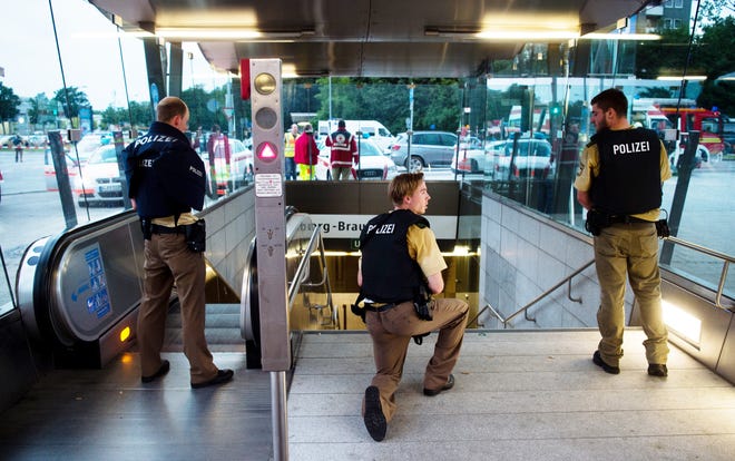 Policemen stand at the underground station Georg-Brauchle-Ring close to the Olympia shopping centre in which a shooting was reported in Munich, southern Germany, Friday July 22, 2016. According to media reports police expect several people being killed. (Lukas Schulze/dpa via AP)