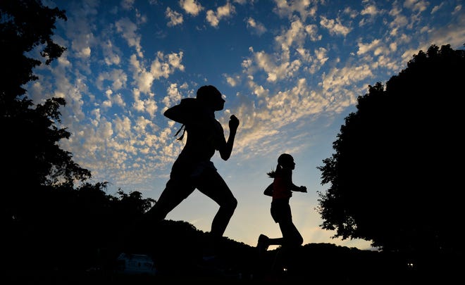 RON JOHNSON/JOURNAL STAR Competitors in the Jr. High School division of the Detweiler at Dark races run the historic cross country course at twilight on Friday.