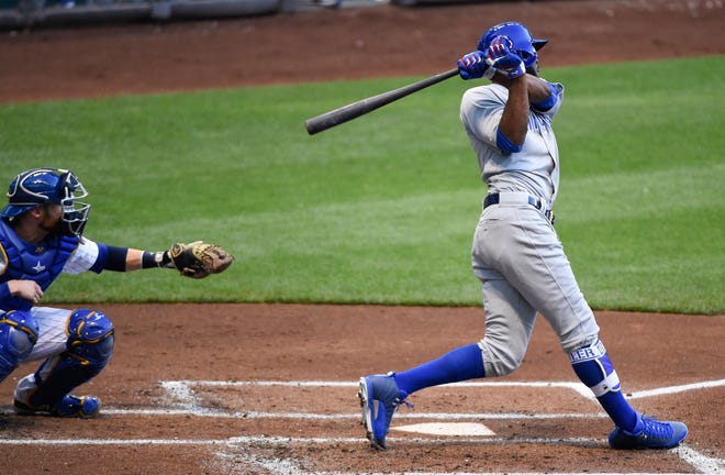 Chicago Cubs' Dexter Fowler follows through on a two-run double off Milwaukee Brewers starting pitcher Jimmy Nelson, in front of catcher Jonathan Lucroy during the second inning of a baseball game Friday, July 22, 2016, in Milwaukee. (AP Photo/Benny Sieu)