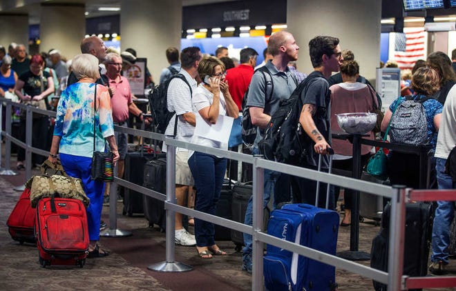 People wait in the Southwest Airlines check-in line at Sky Harbor International Airport, Thursday, July 21, 2016, in Phoenix. Southwest said it has mostly fixed computer problems that caused hundreds of flights to be canceled or delayed, but the airline warned passengers that there could be long lines at airports on Thursday. (Tom Tingle/The Arizona Republic via AP)