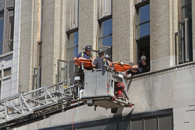 Providence firefighters remove a worker from a window on building on Fulton Street. According to officials, the worker was hit by falling debris on the second floor of the building.