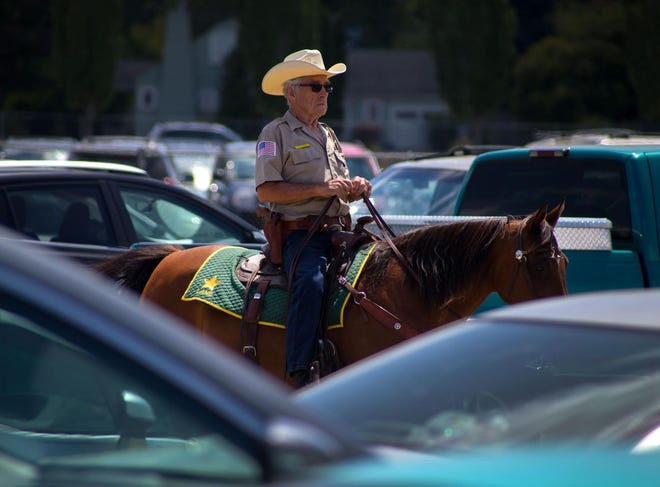 Guy Mattoon rides through the southeast parking lot at the Lane County Fair. (Brian Davies/The Register-Guard)