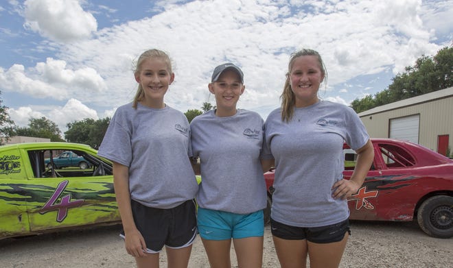 Alison (from left), 14, Ashlyn, 18, and Amber Bird, 21, stand in front of their race cars July 8. While the oldest sister Amber has been racing for seven years, the youngest, Alison, recently started racing. This is the first year all three sisters have raced together.