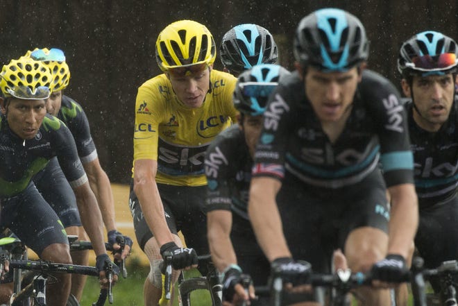 Chris Froome, wearing the overall leader's yellow jersey, and Nairo Quintana, left, climb during the 20th stage Saturday. ASSOCIATED PRESS/PETER DEJONG