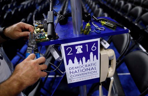 A worker wires a phone on the convention floor as setup continue before the 2016 Democratic Convention in Philadelphia, Saturday, July 23, 2016. (AP Photo/Carolyn Kaster)