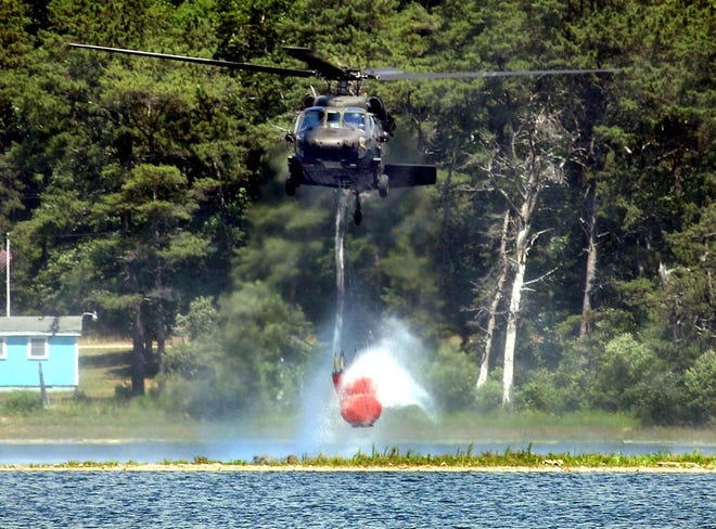 A helicopter drops water at the fire site.