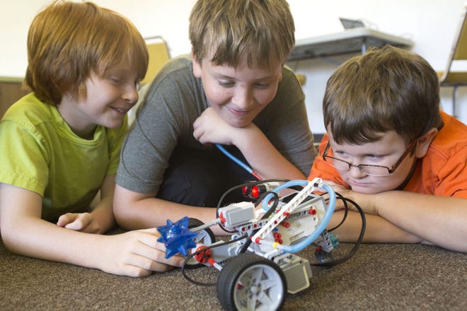 Joseph Gail, left, Devan Fort and Andy Boxx watch as their robot performs a task during the robotics camp at Faith Lutheran School on Tuesday. CINDY DIAN / CORRESPONDENT