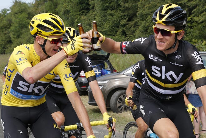 Chris Froome, wearing the overall leader's yellow jersey, and his Sky teammate Geraint Thomas toast with bottles of beer during the 21st and final stage of the Tour de France on Sunday. ASSOCIATED PRESS/CHRISTOPHE ENA