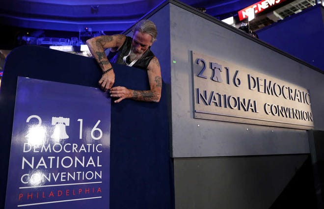 Gary Gort, a set carpenter with CNN, adjusts a sign during preparations before the 2016 Democratic Convention on Sunday in Philadelphia.