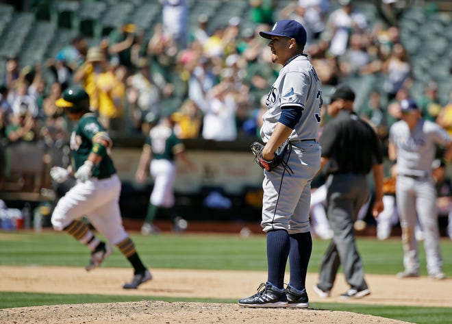 Tampa Bay Rays relief pitcher Erasmo Ramirez, front right, stands on the mound after giving up a home run to Oakland Athletics' Billy Butler, back left, in the eighth inning of a baseball game Sunday, July 24, 2016, in Oakland, Calif.