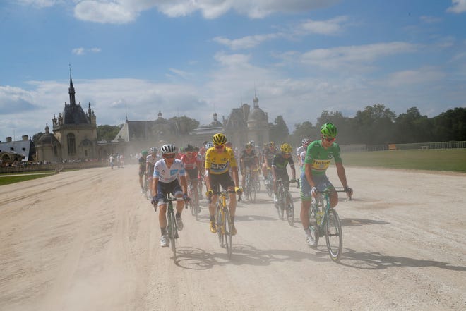 The race director's car kicks up dust as Britain's Chris Froome, wearing the overall leader's yellow jersey, Slovakia's Peter Sagan, wearing the best sprinter's green jersey, Poland's Rafal Majka, wearing the best climber's dotted jersey and Britain's Adam Yates, wearing the best young rider's white jersey, ride in the ceremonial parade preceding the twenty-first stage of the Tour de France cycling race over 113 kilometers (70.2 miles) with start in Chantilly and finish in Paris, France, Sunday, July 24, 2016.