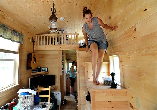 Kori Feener, a documentary filmmaker who has been working with Natick Community Organic Farm this year, climbs down from her bedroom as she moves into the tiny house she plans to live in at the farm. Feener has already spent a couple nights in her new home. (Daily News and Wicked Local Staff Photo/Ken McGagh)