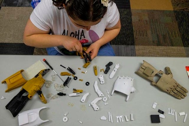 Sarah Esquela, 17, works to assemble a prosthetic hand that is being made for a military veteran who lost a hand during TOM:DC Makeathon at Nova Labs in Reston, Va., on Sunday. Jahi Chikwendiu/The Washington Post