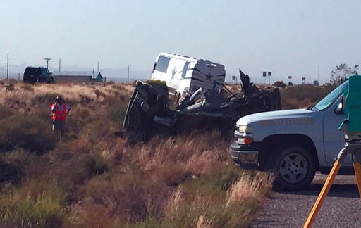 The scene of a bus crash is surveyed Sunday, July 24, 2016, on a highway in northwestern Arizona, about 30 miles north of Kingman. A Dallas Cowboys bus collided with another vehicle and authorities say at least one person was killed. Team spokesman Rich Dalrymple confirmed a Cowboys bus was one of two vehicles involved in the crash Sunday on U.S. 93. (Cody Davis/Kingman Daily Miner via AP)