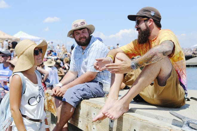 From left, Katelyn Fitzsimmons and Matt Giard of New Bedford chat with their new aquaintance Sam Rubin of Wooster, Mass. during the Newport Folk Festival on Friday at Fort Adams.