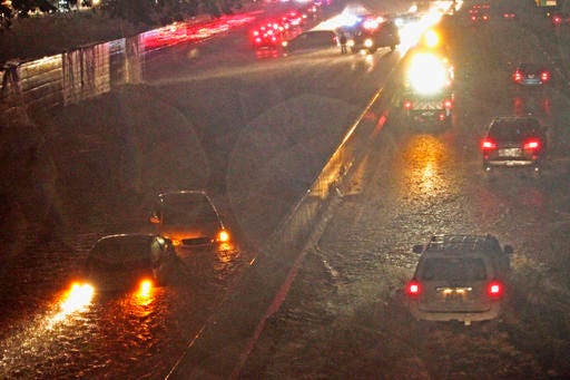 In this Sunday, July 24, 2016 photo, two automobiles are seen submerged in flood water on the westbound lanes of the H-1 freeway, as heavy rain falls during tropical storm Darby in Honolulu. The first storm of the hurricane season to impact Hawaii sent the islands' residents into hurried preparation mode, but the state got through the weekend without seeing major damage as the storm was downgraded, officials said Monday. (Jamm Aquino/The Star-Advertiser via AP)