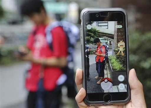 Japanese students play "Pokemon Go" in the street as its released in Tokyo, Friday, July 22, 2016. "Pokemon Go" is expected to be a huge hit in Japan, the country of the character's birth. Fans have been eagerly awaiting its release since it first came out more than two weeks ago in Australia, New Zealand and the United States, and then became a blockbuster hit in more than 20 countries. (AP Photo/Koji Sasahara)
