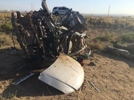 The wreckage of a van that collided with a Dallas Cowboys bus is seen near Kingman, Ariz., Sunday, July 24, 2016. Authorities said multiple people in the van died but nobody on the bus was seriously injured. (Barry White/KTNV via The AP)