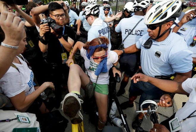 A demonstrator is taken into custody by police after climbing over a barricade near the AT&T Station, Monday, July 25, 2016, in Philadelphia, during the first day of the Democratic National Convention. (AP Photo/Matt Slocum)