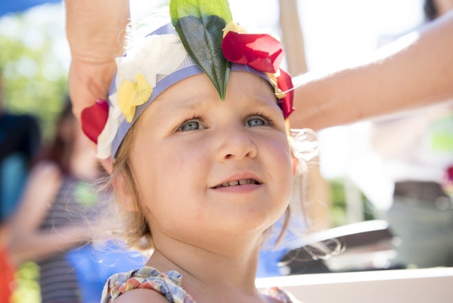 Madelyn May, 2, looks up at her mother Alyssa May as she secures a flower headband that they made together. Wicked Local Staff Photo/ Sam Goresh