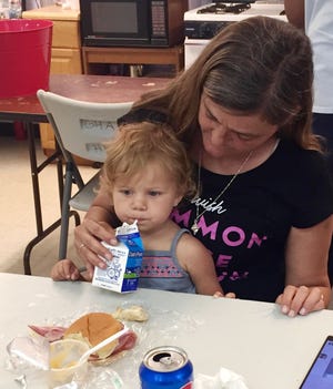 Jasmine eats lunch with help from her grandmother, Brenda, provided by the Cape Ann Summer Meals Program at Riverdale Park in Gloucester. WICKED LOCAL PHOTO / ALYSE DIAMANTIDES