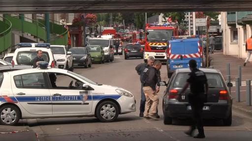 In this grab made from video, police officers speak to a driver as they close off a road during a hostage situation in Normandy, France, Tuesday, July 26, 2016. (BFM via AP)