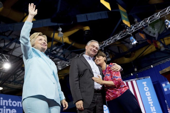 Democratic presidential candidate Hillary Clinton, left, waves as her vice presidential choice Sen. Tim Kaine, D-Va., center, hugs his wife Anne Holton, right, during a rally at Florida International University Panther Arena in Miami on Saturday. AP Photo/Andrew Harnik