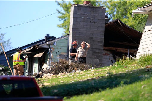 Law enforcement investigators in Omaha, Neb., look for clues Tuesday, July 26, 2016, at the scene of a house where an explosion took place on Monday, killing a woman, in Omaha. Authorities say the woman was a property inspector sent to check its condition after a tenant was evicted. (AP Photo/Nati Harnik)