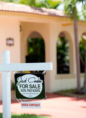 This Tuesday, July 19, 2016, photo shows a sign announcing that a home is for sale and under contract in Surfside, Fla. On Tuesday, July 26, 2016, the Standard & Poor's/Case-Shiller 20-city home price index for May is released. (AP Photo/Wilfredo Lee)