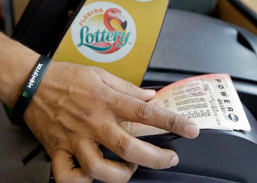 FILE - In this Jan. 13, 2016 file photo, a clerk at a convenience store pulls Powerball tickets from a printer for a customer in Tampa, Fla. The Powerball jackpot for the Wednesday, July 27, 2016, drawing has soared to over $420 million thanks to nearly three months without a winner of the big prize. (AP Photo/Chris O'Meara, File)