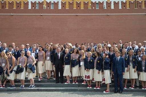 President of Russia's Olympic Committee Alexander Zhukov, fourth right, and Sports Minister Vitaly Mutko, center, pose for a photo with Russia's National Olympic team members outside the Kremlin wall, before a meeting with Russian President Vladimir Putin, in Moscow, Russia, Wednesday, July 27, 2016. At least 105 athletes from the 387-strong Russian Olympic team announced last week have been barred from the Rio Games in connection with the country's doping scandal. (AP Photo/Pavel Golovkin)