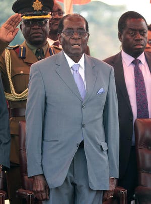 Zimbabwean President Robert Mugabe sings the national anthem before addressing the Zimbabwe National Liberation War Veterans Association, at the party headquarters, in Harare, Wednesday, July, 27, 2016. Zimbabwe's 92-year-old president on Wednesday said the longtime loyalists who turned against him last week should face "severe" punishment, and he vowed to stay in power for "a long time." (AP Photo/Tsvangirayi Mukwazhi)