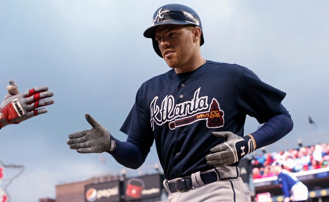 Atlanta Braves' Freddie Freeman is welcomed at the dugout after his two-run home run off Minnesota Twins pitcher Michael Tonkin during the fourth inning of a baseball game Wednesday, July 27, 2016, in Minneapolis. (AP Photo/Jim Mone)