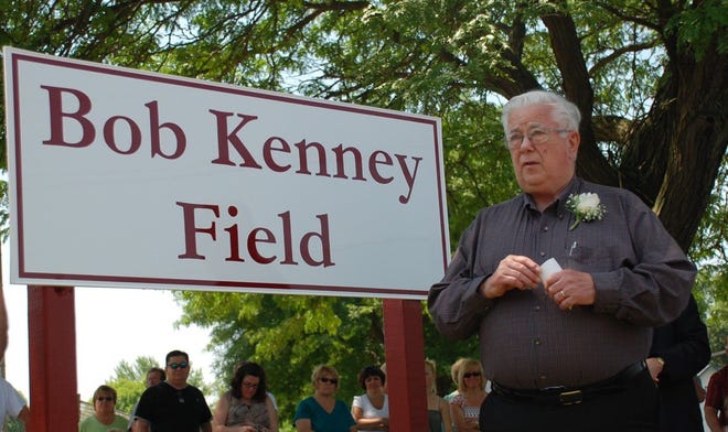 Bob Kenney stands next to a sign bearing his name in 2009 at the dedication of the athletic field in his name on Hooker Street in Riverside.