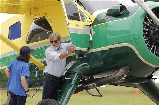 Harrison Ford opens the door on his plane for Jodie Gawthorp, of Westchester, Ill., who was selected to fly with Ford, at the Experimental Aircraft Associations AirVenture air show at Wittman Regional Airport in Oshkosh, Wis., Thursday, July 28, 2016. The "Star Wars" and "Indiana Jones" star was accompanied by Gawthrop when he flew his DeHavilland Beaver on Thursday at the AirVenture Oshkosh 2016 air show. (Joe Sienkiewicz/The Oshkosh Northwestern via AP)