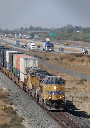 FILE - In this Thursday, Oct. 10, 2013, file photo, a freight train travels south alongside Highway 99 near Livingston, Calif. Freight railroads might be forced to allow rivals to serve some customers along their tracks under a new proposed rule, announced Wednesday, July 27, 2016. Federal regulators say that if shippers can show they don’t have many shipping options and can meet certain conditions, they should be able to get bids from competing railroads to haul their products. Railroads say the rule is unneeded and would make shipments less efficient. (AP Photo/Rich Pedroncelli, File)