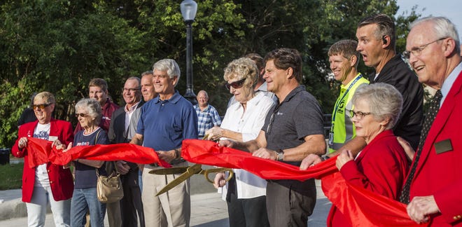 Salina Mayor Kaye Crawford (center, with scissors) cuts the ribbon at the opening of the recently reconstructed Greeley Avenue bridge Thursday.